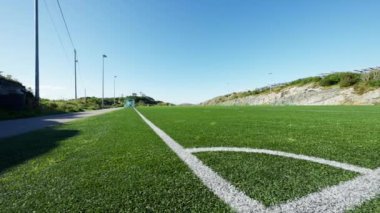Futbol sahasının köşesinde soldan sağa doğru hareket eden bir atış.