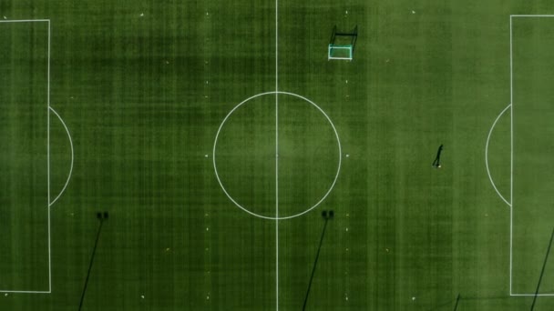 一个足球场的俯视图 它显示了一个孤独的人在走路 然后逐渐地缩进球场的中心圈 — 图库视频影像