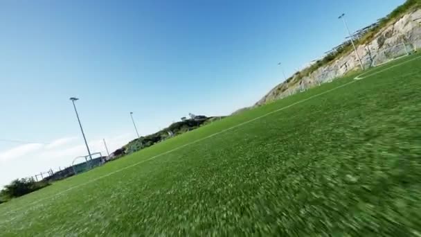 Bir Açık Mavi Gökyüzünün Altında Bir Futbol Sahasının Üzerinde Uçuyor — Stok video