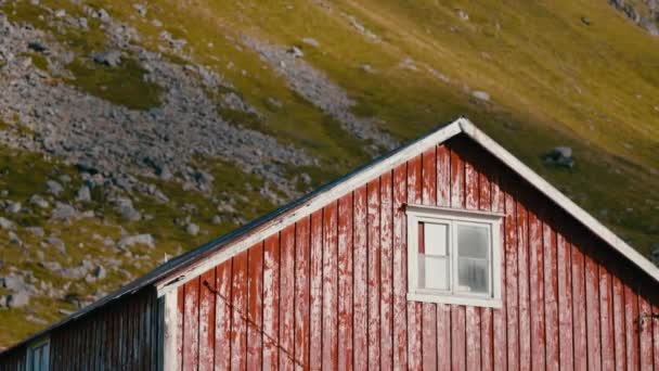 天候の良い赤い納屋は 草と岩に囲まれた山の斜面に囲まれました — ストック動画