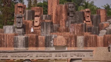 Meraklı bir kadın Tayland 'ın Ko Chang şehrinde gündüz vakti taş kafalarla süslenmiş unutulmuş bir havuzun ürkütücü ama büyüleyici güzelliğini yakalıyor.