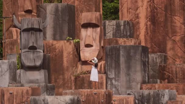 Kobieta Białej Sukience Oddaje Mistykę Urok Kamiennych Głów Opuszczonym Hotelu — Wideo stockowe