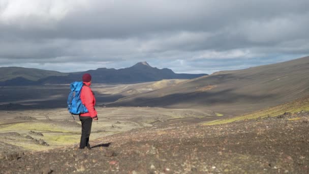 カメラはゆっくりとジャケットの男にズームし バックパックで 彼はヒスカ火山の近くのラウダスカルクレーターのベースで周囲を観察します — ストック動画