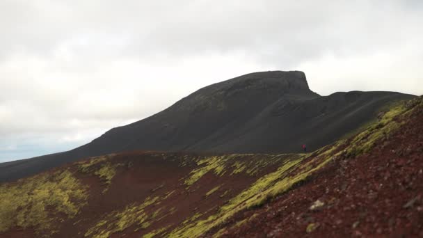 在多云的天空下 在Hekla火山附近冰岛著名的Raudhaskal陨石坑上 一个徒步旅行者拍了一张广角照片 — 图库视频影像