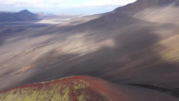 ブラック火山灰とラウダスカルクレーターの近くの赤い火山の土壌に緑色のモスの層をフィーチャーしたハイラス火山の地形の空中撮影 — ストック動画