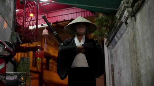 一个武士女人在夜间自信地穿过一条狭窄的小巷 — 图库视频影像