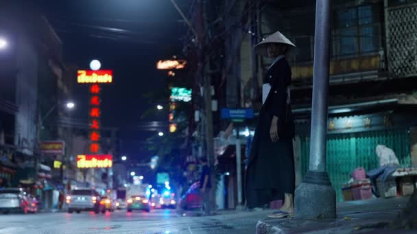 一位身着传统和服 头戴草帽的女士优雅地站在人行道上 在热闹的都市风景中捕捉着片刻的宁静 — 图库视频影像