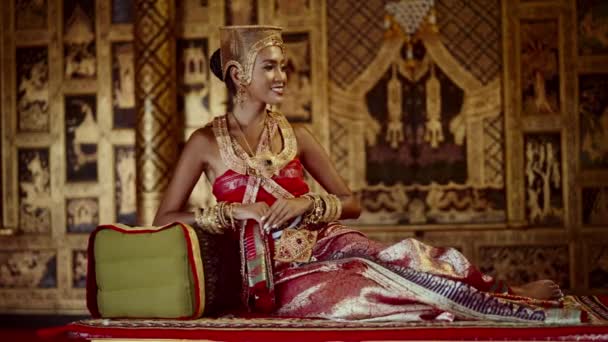 Uma Mulher Vestida Com Trajes Tradicionais Tailandeses Senta Graciosamente Dentro — Vídeo de Stock