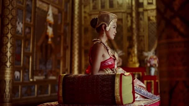 一个女人穿着传统的泰式服装和精美的金饰品 坐在一座泰国庙宇的永恒之美中 — 图库视频影像