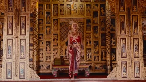 Женщина Традиционной Тайской Одежде Ходит Храму Украшенному Резьбой Яркими Золотыми — стоковое видео