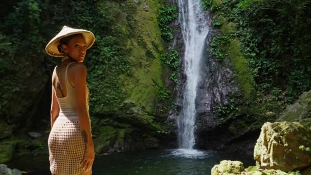 Bikinili Hasır Şapkalı Bir Kadının Gözlerinin Önündeki Orman Şelalesine Bakmak — Stok video