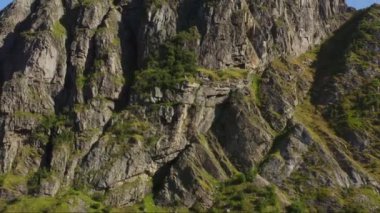 İnsansız hava aracı gündüz vakti yosunlu Lofoten dağını gösteriyor.