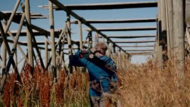 Kendini adamış bir film yapımcısı tripodu ve kamerasıyla gün içinde balık rafında yürüyor.