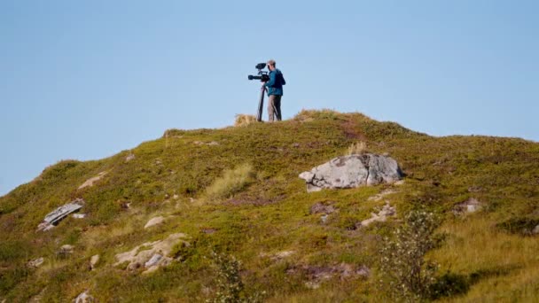 明るい青い空に向かって丘の上の視点から撮影されたシーンを撮影した映画製作者 — ストック動画