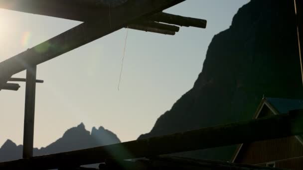 明確な青空と山の背景に対して 伝統的な備蓄ラックから吊り下げられたデカイシュ文字列 — ストック動画