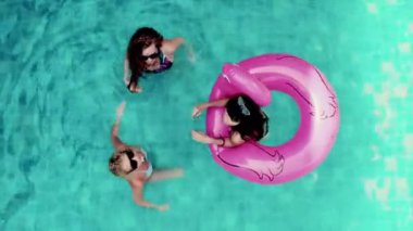 Gündüz vakti havuz başında eğlenen bir grup kadını baştan aşağı görüntülemek