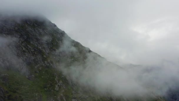 イーサリアルな雲に覆われた山の上にドローンが沈む — ストック動画