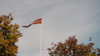 Norveç bayrağı rüzgarda dalgalanır, Norveç 'in ruhunu güzel mavi bir gökyüzünün arka planına somutlaştırır.