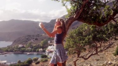 Gündüz vakti nefes kesen dağ zirveleri arasında nefes kesici selfie çeken bir kızın orta boy fotoğrafı.
