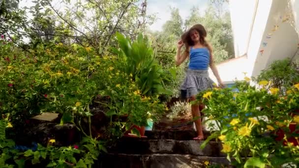 一个女孩正走在花园的楼梯上 在白天欣赏着美丽的花朵 — 图库视频影像