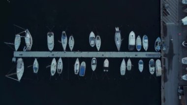 Marinaya yanaşmış tekne ve yatların insansız hava aracı görüntüsü.