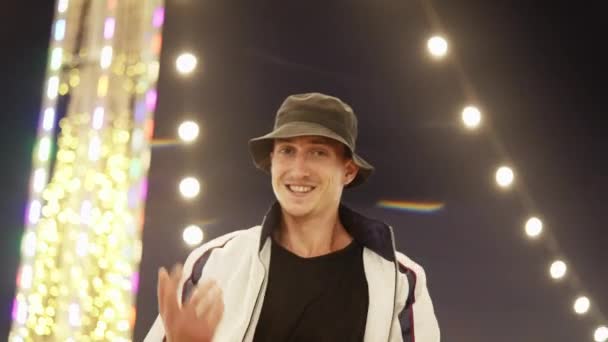 Ένας Νεαρός Άνδρας Φορώντας Ένα Σακάκι Και Ένα Καπέλο Χαμογελά — Αρχείο Βίντεο