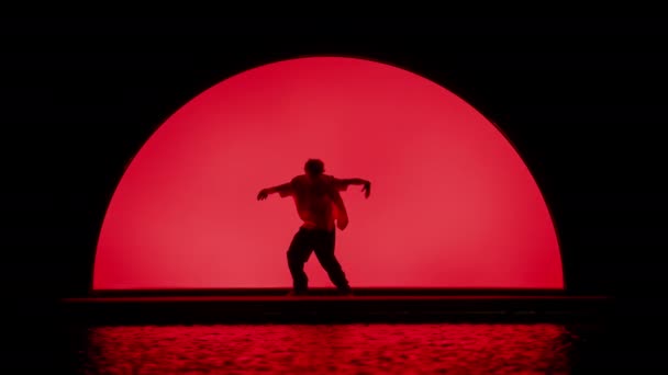 댄서는 빨간색 백라이트로 무대에서 슬로우 모션을 수행합니다 — 비디오