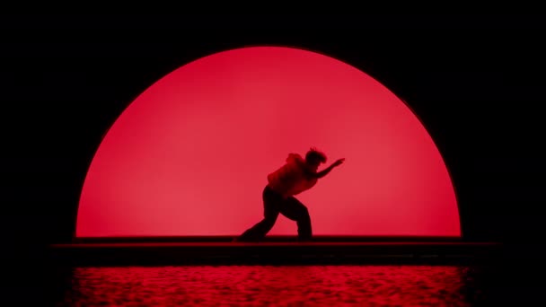 실루에트 댄서는 배경에 대하여 무대에서 예술적 루틴을 수행합니다 — 비디오
