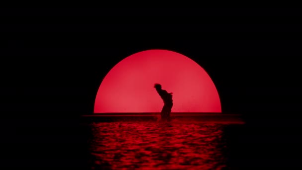 활기찬 빨간색 물에서 남자의 실루엣의 슬로우 — 비디오