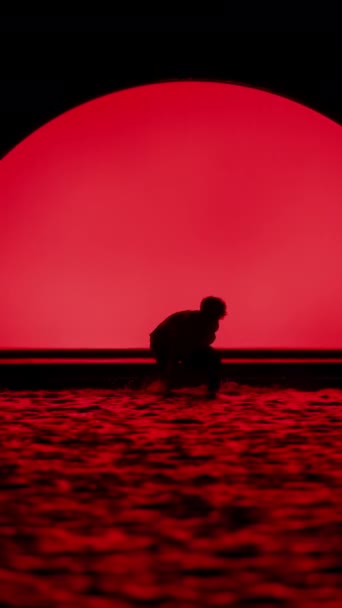 남자의 실루엣 배경에 빨간색 아치와 슬로우 모션에서 물에서 — 비디오