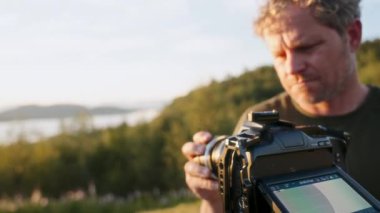 Kendini adamış bir film yapımcısı, kameranın lensini nazikçe takarken hassasiyetini gösterir.