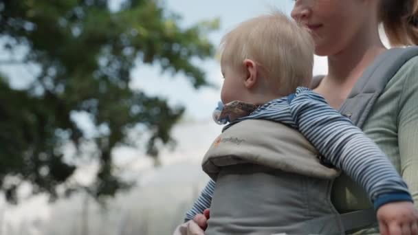 Urocze Dziecko Ssie Uwięzi Podczas Gdy Jego Matka Macha Ręką — Wideo stockowe