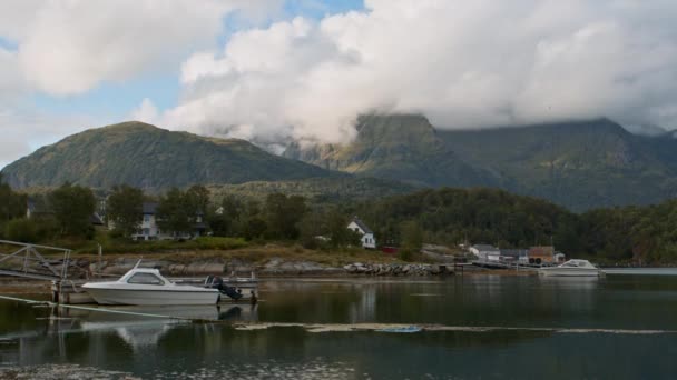 在港湾里 一幅幅由小船和小房子组成的风景画 天空和群山映衬着平静的水面 图库视频片段