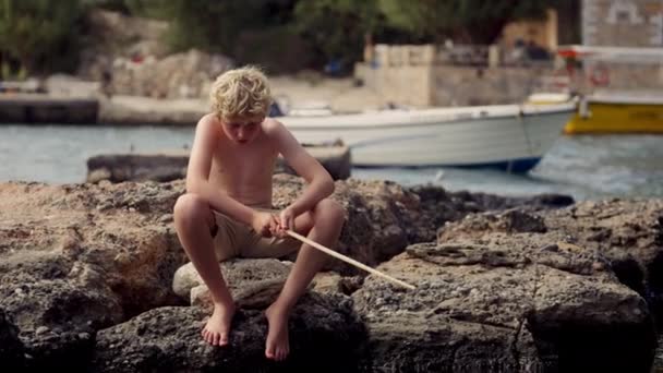 Chlapec Sedí Přes Den Klidně Skále Zády Člun Tichém Rybářském — Stock video