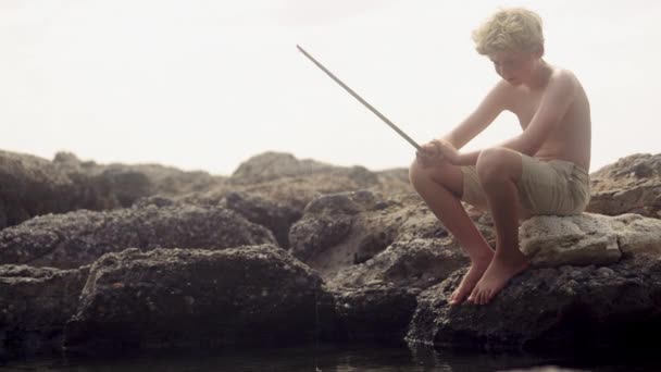 Ein Junge Sitzt Einer Felsigen Küste Und Benutzt Tagsüber Genial — Stockvideo