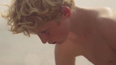 Yakından çekilen bir çocuk gündüz vakti balıkçılık sanatına kendini kaptırmış.