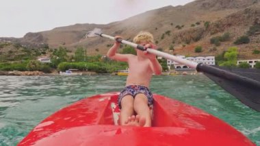 Büyüleyici bir köyün kristal berrak sularında kano süren genç bir kaşif, Akdeniz kıyı şeridinin engebeli kucaklamalarının arasına kurulmuş.