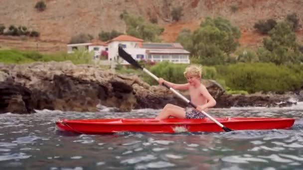 Young Boy Maneuvers Crete Waters Stunning Mediterranean Landscapes Vibrant Red — Stock Video