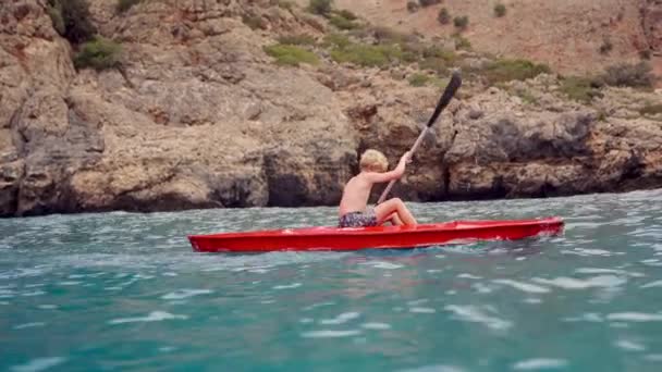 穏やかな海と印象的なコントラストを作成し ジャグジーの崖に対する若々しい探検家のカヤック航海 — ストック動画
