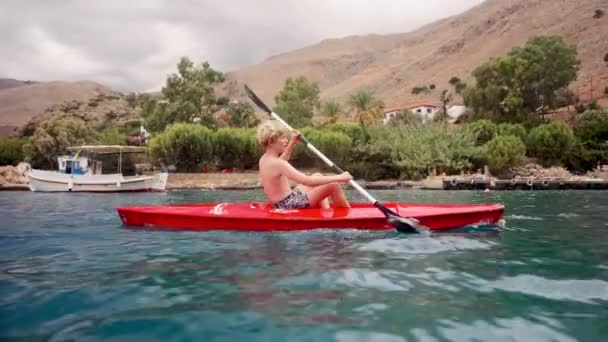 Boy Gliding Waters Crete Red Kayak While Surrounded Island Stunning — Stock Video
