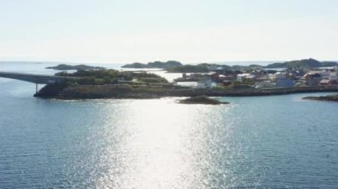 Huzurlu sularda süzülen bir dron büyüleyici Engoysund Köprüsü 'nün yukarısındaki sakin kıyı kasabasını gösteriyor.