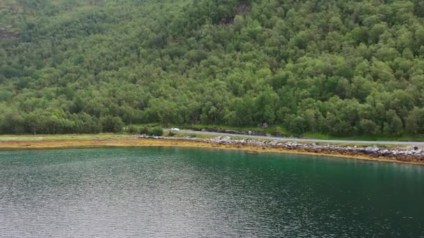 Aerial Shot White Car Traveling Lakeside Road Backdrop Green Mountains — Stock Video