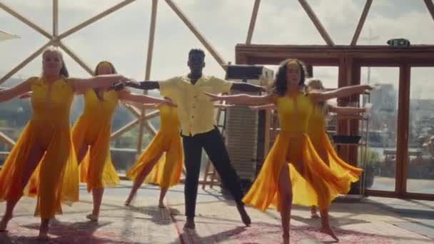 Orange Gekleidete Personen Drücken Ihre Leidenschaft Durch Dynamische Tanzbewegungen Der — Stockvideo