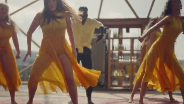 身着橙色服装的人们 在大地圆顶的沉浸环境中 通过生动的舞姿 热情地表达自己的情感 — 图库视频影像
