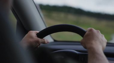 Yakın çekim, direksiyonu sıkıca kavrayan, direksiyonu sıkıca kavrayan, bir araca hassasiyetle ve kontrolle rehberlik eden.