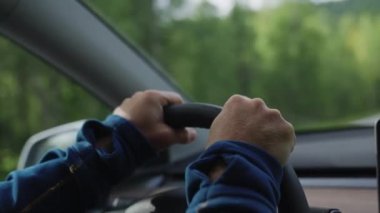 Direksiyonu sıkıca ve kendinden emin bir şekilde tutan, kontrol ve kesinlik hissi veren detaylı bir çekim.
