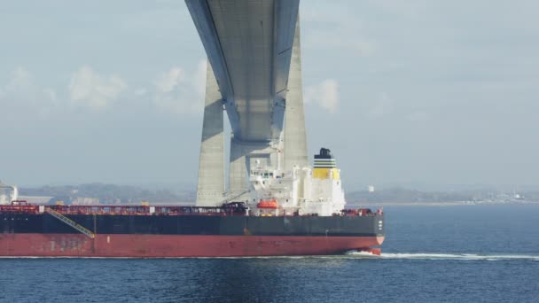 静的なショットは デンマークのグレートベルト橋の下を通過する石油タンカーをキャプチャします — ストック動画