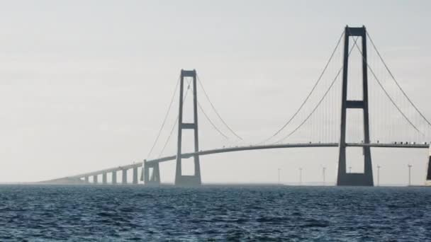 潘的镜头从左移到右移 展示了在丹麦标志性的大贝尔特桥上行驶的汽车 — 图库视频影像
