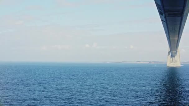 パンはデンマークの穏やかな海にグレートベルト橋をキャプチャする右から左に移動撮影しました — ストック動画