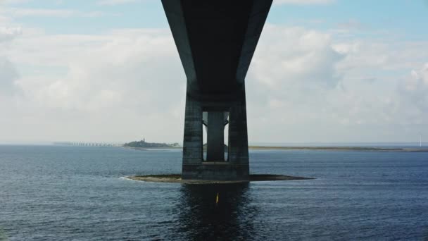 デンマークの景色を背景に巨大な構造を捉えたグレートベルト橋の壮大な下に静的なショット — ストック動画